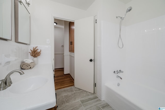 bathroom featuring bathtub / shower combination, vanity, hardwood / wood-style flooring, and tile walls