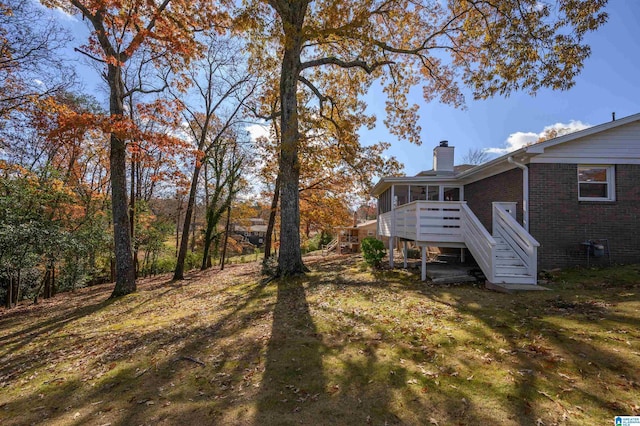 view of yard featuring a deck and a sunroom