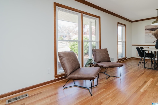 sitting room featuring a wealth of natural light, light hardwood / wood-style floors, and ornamental molding