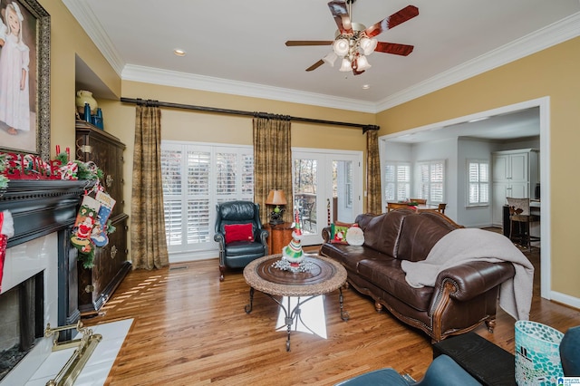 living room with plenty of natural light, crown molding, and light hardwood / wood-style flooring