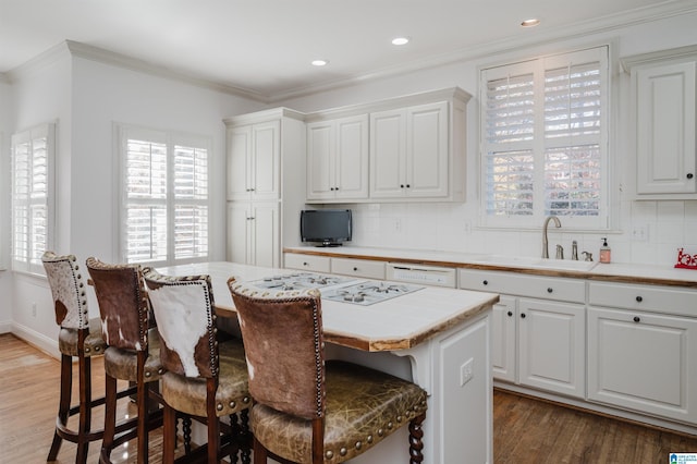 kitchen with a kitchen bar, white cabinetry, a kitchen island, and tasteful backsplash