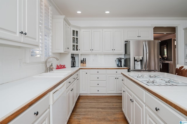 kitchen featuring sink, light hardwood / wood-style flooring, crown molding, white appliances, and white cabinets