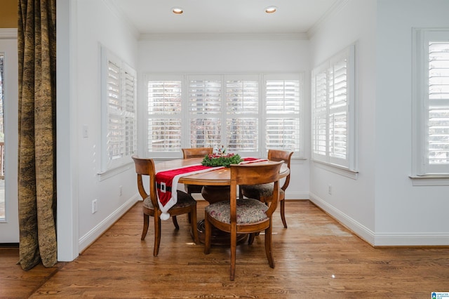 dining space with hardwood / wood-style flooring, a wealth of natural light, and crown molding