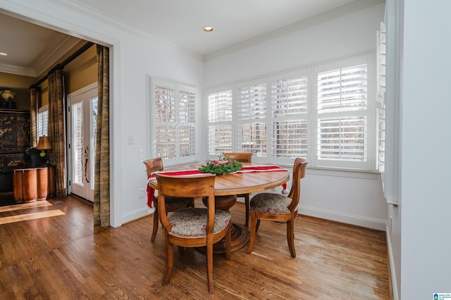 dining space with hardwood / wood-style floors and crown molding