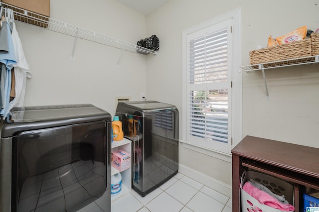 laundry area featuring light tile patterned floors and washer and dryer