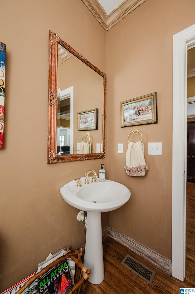 bathroom featuring crown molding and wood-type flooring