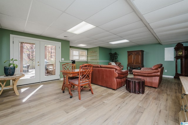 living room featuring french doors, a paneled ceiling, and light hardwood / wood-style flooring