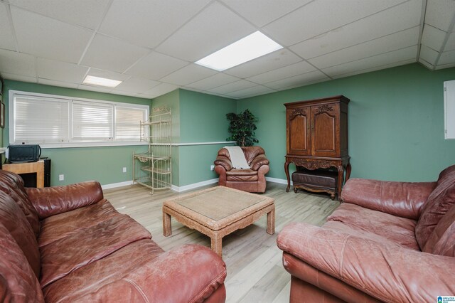 living room featuring light hardwood / wood-style floors and a drop ceiling