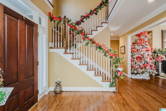 foyer entrance with light hardwood / wood-style floors and ornamental molding