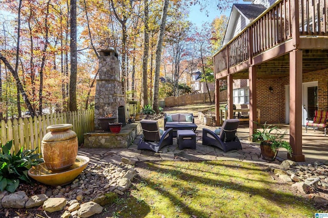 view of yard featuring an outdoor living space with a fireplace, a patio area, and a wooden deck