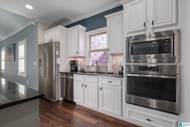 kitchen featuring dark hardwood / wood-style flooring, ornamental molding, stainless steel appliances, sink, and white cabinets