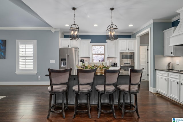 kitchen with dark hardwood / wood-style flooring, plenty of natural light, hanging light fixtures, and appliances with stainless steel finishes