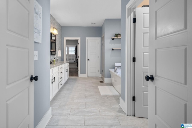 bathroom featuring tile patterned flooring, vanity, and a bathtub