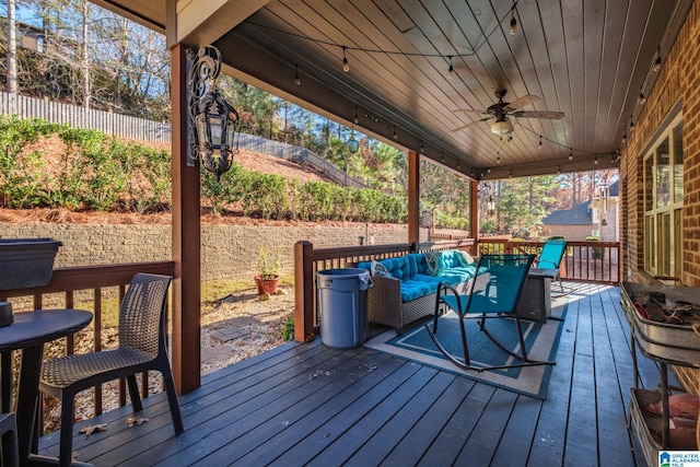 wooden deck with outdoor lounge area and ceiling fan