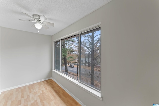 empty room with a textured ceiling, light hardwood / wood-style flooring, and ceiling fan