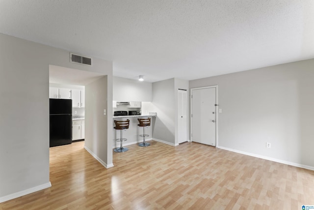 interior space featuring a textured ceiling and light hardwood / wood-style flooring