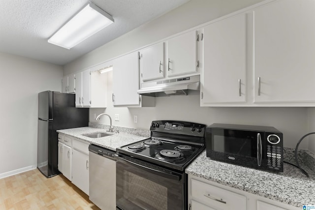 kitchen with sink, light stone counters, light hardwood / wood-style floors, white cabinets, and black appliances