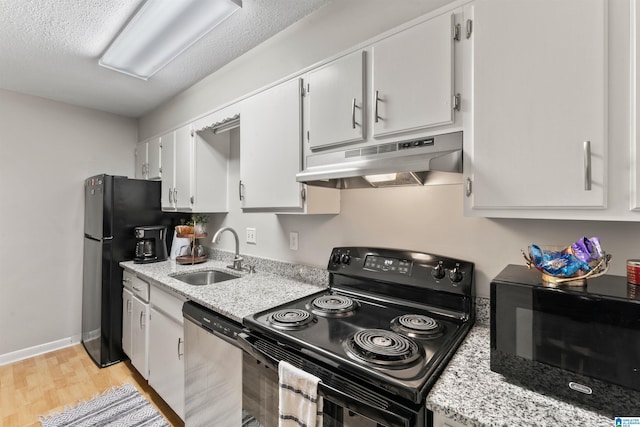 kitchen with sink, light hardwood / wood-style flooring, white cabinets, and black appliances