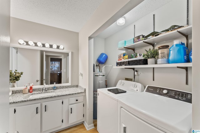 washroom featuring sink, light hardwood / wood-style flooring, a textured ceiling, hookup for a washing machine, and water heater