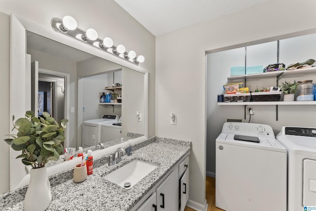 bathroom with vanity, washer and dryer, and a textured ceiling