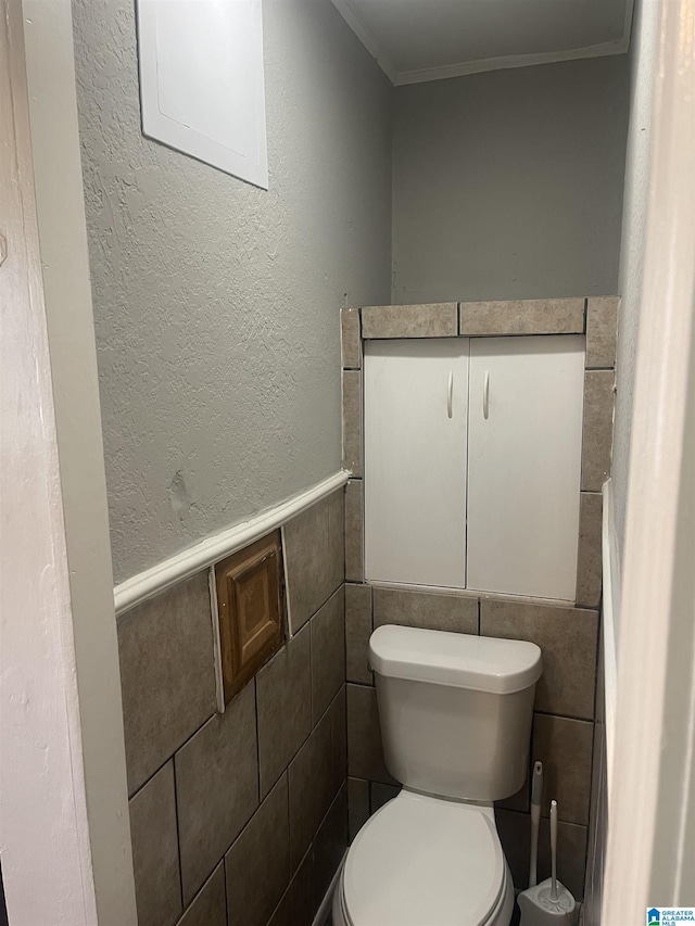 bathroom featuring toilet and crown molding