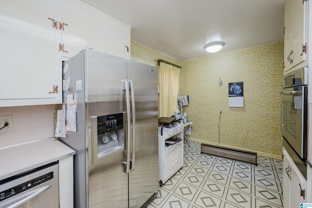 kitchen featuring white cabinets, appliances with stainless steel finishes, and a baseboard radiator