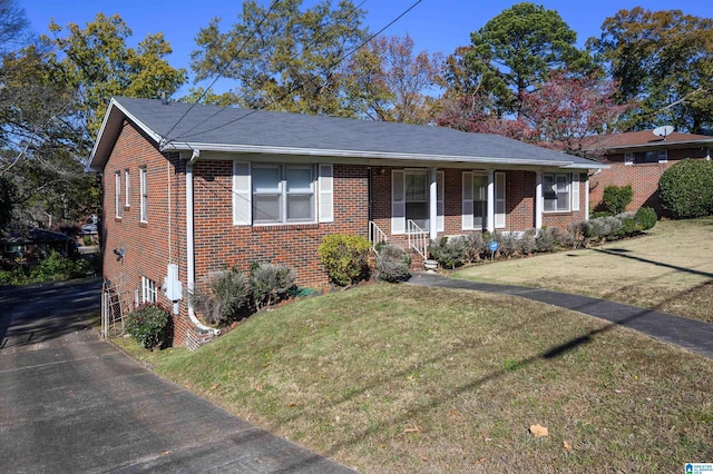 ranch-style home featuring a front lawn and covered porch