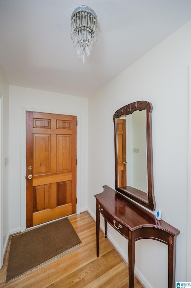 entrance foyer with a notable chandelier and wood-type flooring