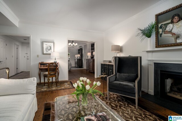 living room featuring dark hardwood / wood-style flooring, an inviting chandelier, and ornamental molding