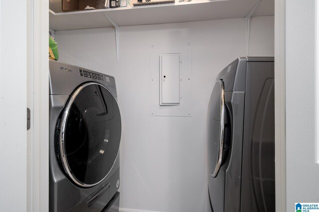 clothes washing area featuring electric panel and washer and dryer