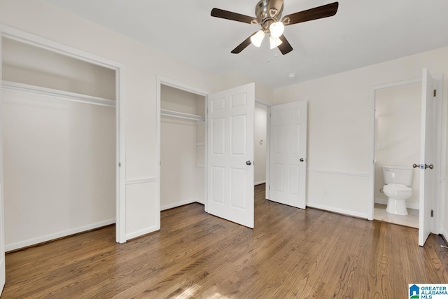 unfurnished bedroom with dark hardwood / wood-style flooring, ensuite bath, and ceiling fan