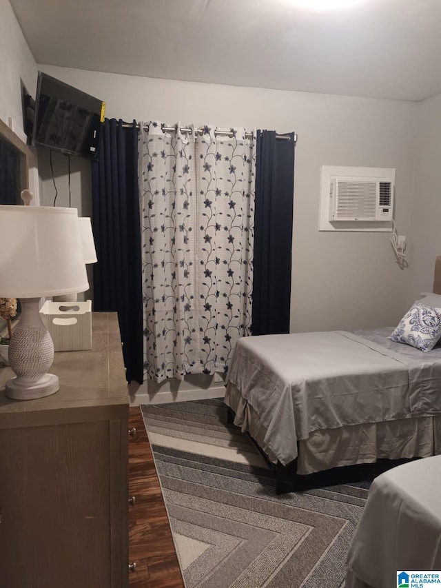 bedroom with a wall mounted air conditioner and dark hardwood / wood-style floors