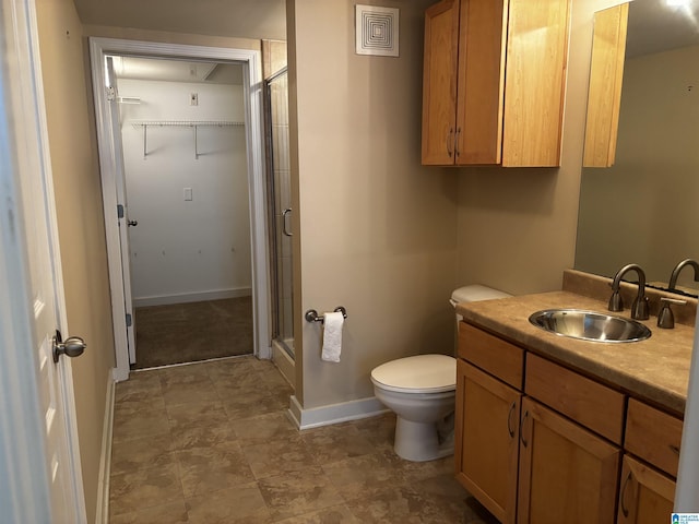 bathroom with a shower with door, vanity, and toilet