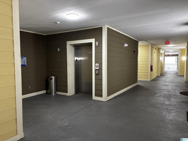 hall featuring elevator and wooden walls