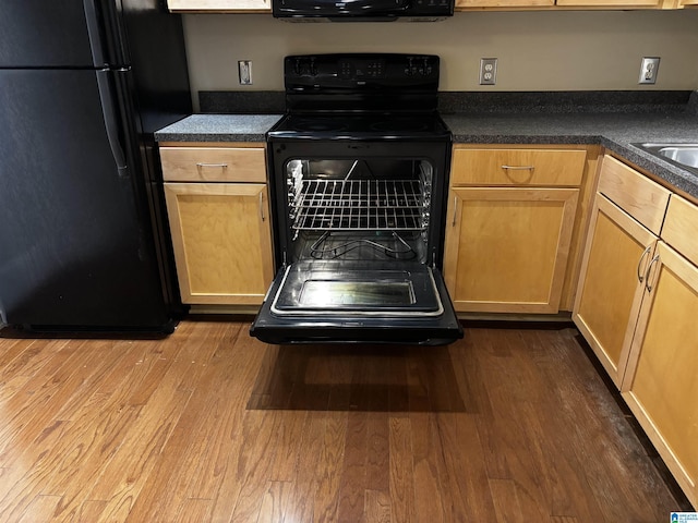 kitchen featuring wood-type flooring and black appliances