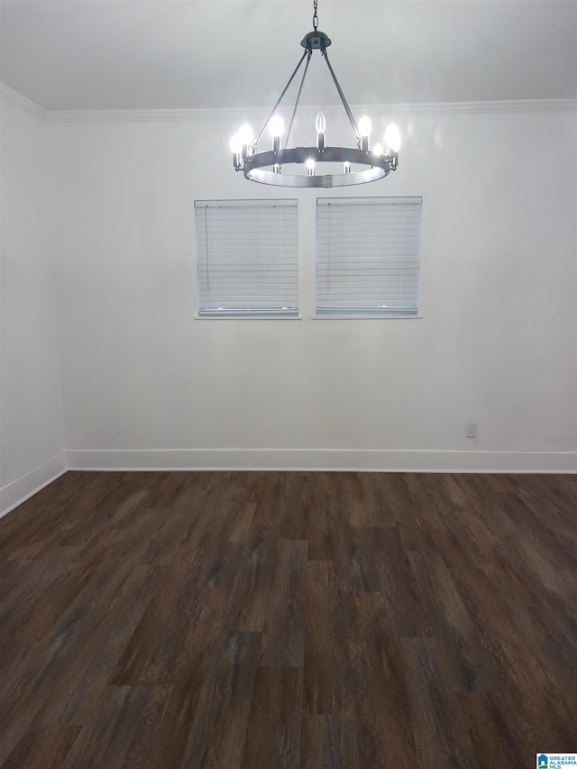 unfurnished dining area with dark wood-type flooring, ornamental molding, and a notable chandelier