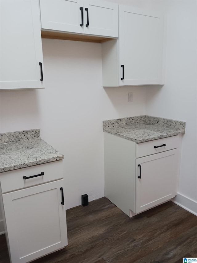 kitchen featuring white cabinetry, light stone counters, and dark hardwood / wood-style floors