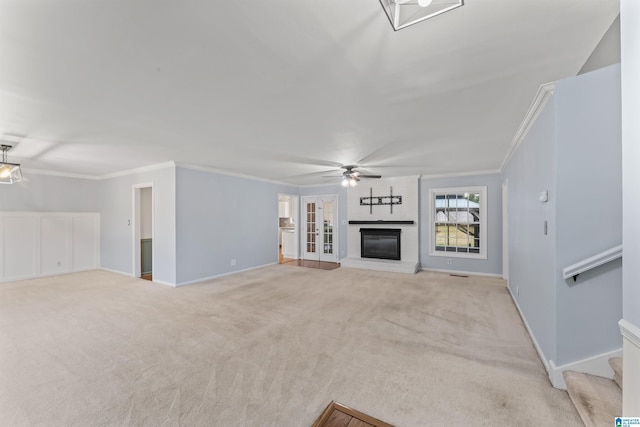 unfurnished living room featuring light carpet, a brick fireplace, ceiling fan, and ornamental molding