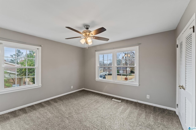 unfurnished bedroom with multiple windows, ceiling fan, and carpet floors