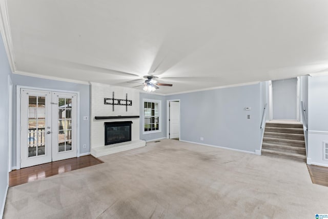 unfurnished living room with a healthy amount of sunlight, ornamental molding, and french doors