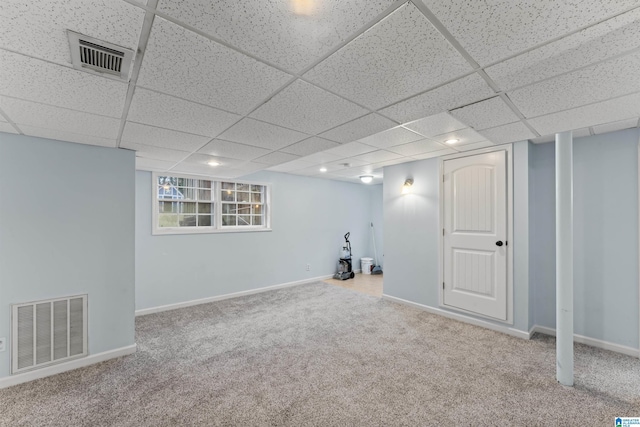 basement featuring a paneled ceiling and carpet