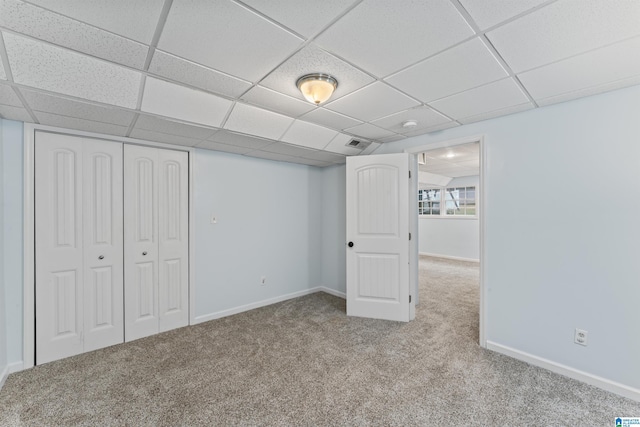 basement with light colored carpet and a drop ceiling