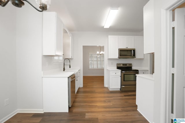 kitchen featuring white cabinetry, an inviting chandelier, dark hardwood / wood-style floors, and appliances with stainless steel finishes