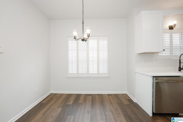 unfurnished dining area featuring dark wood-type flooring and a chandelier