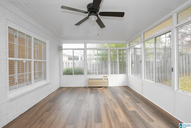 unfurnished sunroom with a wall mounted air conditioner, ceiling fan, and a healthy amount of sunlight