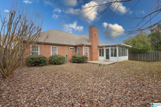 back of property with a sunroom and a patio area