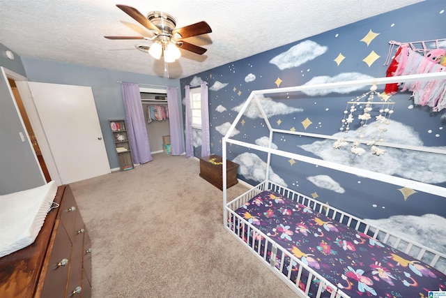 bedroom featuring carpet flooring, a textured ceiling, a closet, and ceiling fan