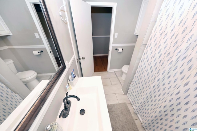 bathroom with tile patterned floors, a shower with curtain, toilet, and vanity