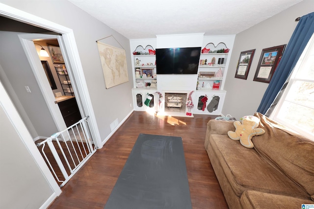 living room featuring a textured ceiling and dark wood-type flooring