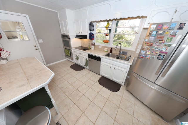 kitchen featuring white cabinetry, sink, tile counters, light tile patterned flooring, and appliances with stainless steel finishes